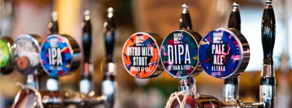 A row of Galway Bay tap badges including Buried at Sea nitro milk stout, Of Foam and Fury double IPA and Althea pale ale.