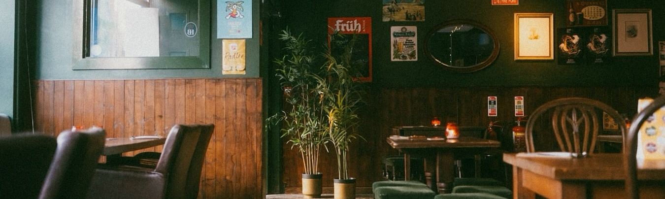 Inside Molly's: deep green walls, wood panelling, framed prints, candlelit tables and green velvet stools.